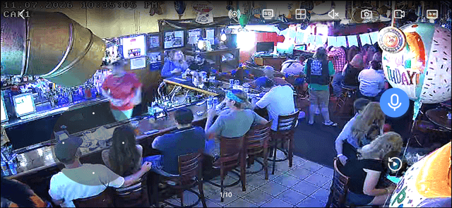 Security-camera footage of a crowded bar on a busy night, with a birthday balloon decoration among the guests.